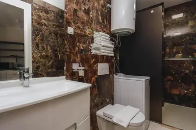 a bathroom with a sink and a toilet and a mirror at Sunrio Apartments in Budva