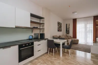 a kitchen and living room with a table and chairs at Sunrio Apartments in Budva