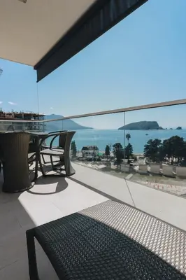 a balcony with a table and a view of the ocean at Sunrio Apartments in Budva