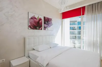 a bedroom with a white bed and a window at Sunrio Apartments in Budva
