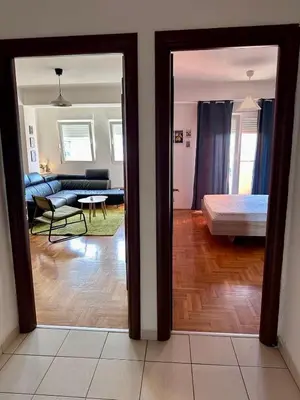a view of a living room with a couch and a bed at Bright & Cozy Urban Apartment in Podgorica