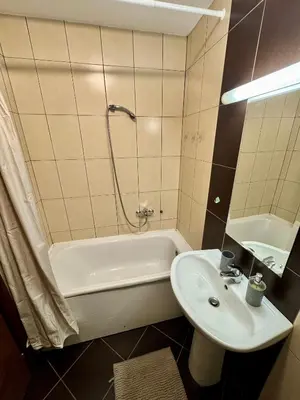 a bathroom with a tub and a sink and a bath tub at Bright & Cozy Urban Apartment in Podgorica
