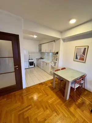 a kitchen and dining room with a table and chairs at Bright & Cozy Urban Apartment in Podgorica
