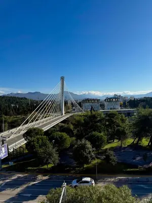 a bridge in a city with cars parked at Milenijum apartman in Podgorica