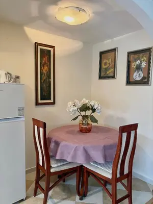 a dining room table with a vase of flowers on it at Milenijum apartman in Podgorica
