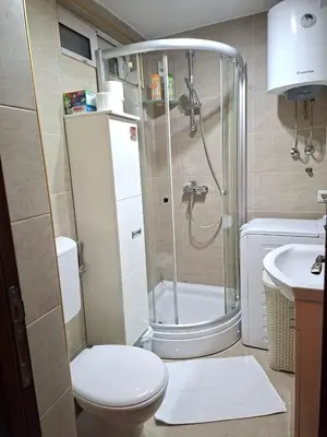 a bathroom with a shower and a toilet and a sink at Milenijum apartman in Podgorica