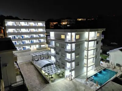 an apartment building with a swimming pool at night at Aqua Lounge Aparthotel Ulcinj in Ulcinj