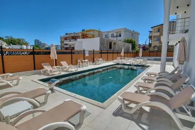 a pool with chaise lounge chairs and a bunch ofitures at Aqua Lounge Aparthotel Ulcinj in Ulcinj