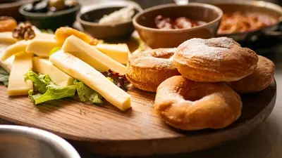 a wooden plate with pastries and cheese on a table at Aqua Lounge Aparthotel Ulcinj in Ulcinj