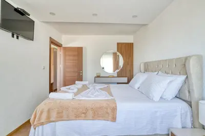 a bedroom with a large white bed and a mirror at Aqua Lounge Aparthotel Ulcinj in Ulcinj
