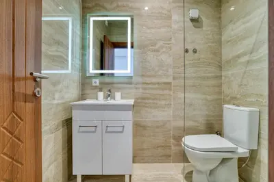 a bathroom with a toilet and a sink and a mirror at Aqua Lounge Aparthotel Ulcinj in Ulcinj