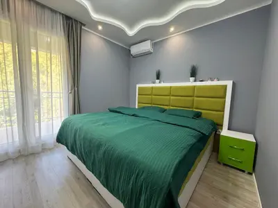 a bedroom with a large bed with a green bedspread at Lucky Space 3 Apartment in Budva