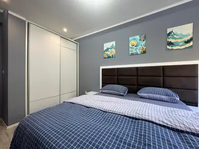 a bedroom with a blue bed with two blue pillows at Lucky Space 3 Apartment in Budva