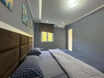 a bedroom with a large bed with blue walls at Lucky Space 3 Apartment in Budva