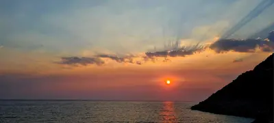 a sunset over the ocean with the sun in the sky at Tramontana in Dobra Voda