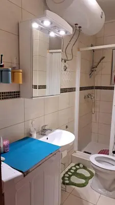 a bathroom with a sink and a toilet and a mirror at Sheldon in Budva