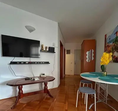 a living room with a table and a tv on a wall at Sheldon in Budva