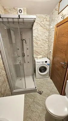 a bathroom with a shower and a washing machine at OldAirport in Podgorica