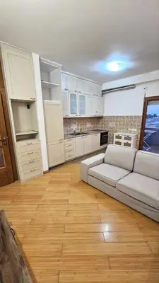 a living room with a couch and a kitchen at OldAirport in Podgorica