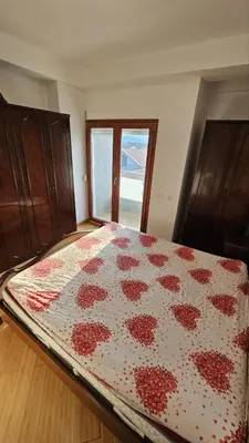 a bedroom with a bed with a red and white quilt at OldAirport in Podgorica