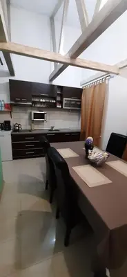 a kitchen with a table and chairs and a kitchen with apertureperture at Zlatna Guest House in Kotor