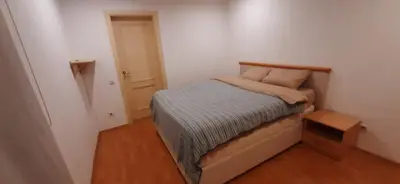 a small bedroom with a bed and a night stand at Zlatna Guest House in Kotor