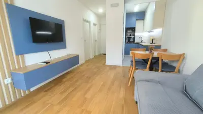 a living room with a tv and a table and chairs at Apartments LORA Novi Bar in Bar