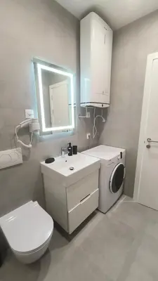 a bathroom with a toilet and a sink and a washing machine at Apartments LORA Novi Bar in Bar