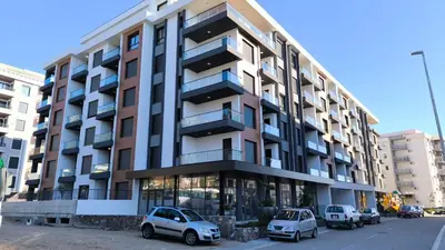 a building with cars parked in front of it at Apartments LORA Novi Bar in Bar