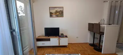 a room with a television and a table with a mirror at Nikola apartment in Podgorica