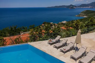 a villa with a pool and a view of the ocean at Olive Resort in Petrovac na Moru