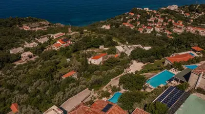an aerial view of a house on a hill with a pool at Olive Resort in Petrovac na Moru