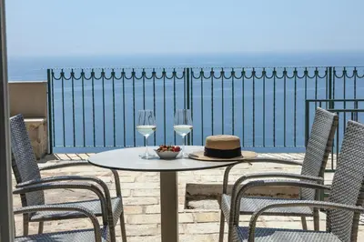 a table with two glasses of wine and two chairs at Olive Resort in Petrovac na Moru