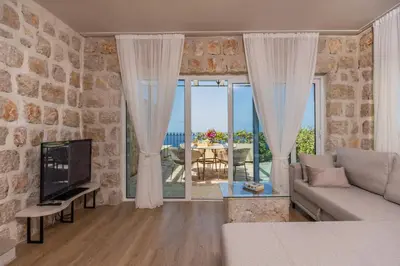 a living room with a couch and a large window at Olive Resort in Petrovac na Moru