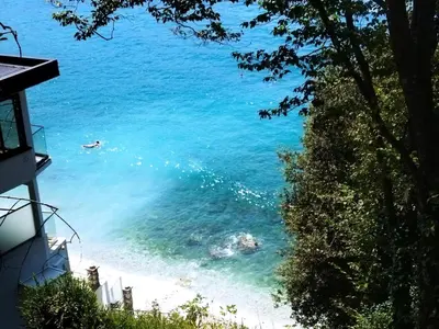 a view of a beach with a person swimming in the water at Beach House Kruče in Ulcinj