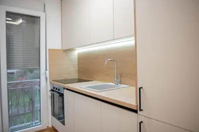a kitchen with white cabinets and a sink at Phenix Apartments Parking FREE in Podgorica