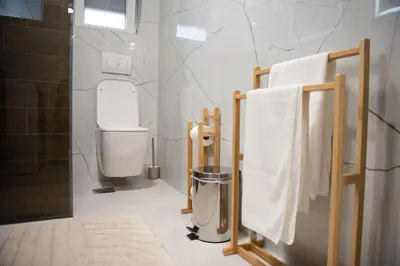 a bathroom with a shower and a toilet and towels at Phenix Apartments Parking FREE in Podgorica