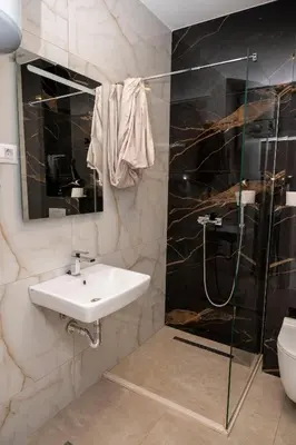a bathroom with a sink and a shower at RiverBank Apartmani in Podgorica