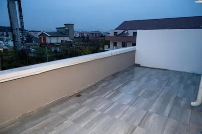 a balcony with a white wall and a view of a city at RiverBank Apartmani in Podgorica