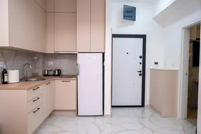 a kitchen with white cabinets and a white refrigerator at RiverBank Apartmani in Podgorica