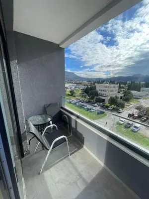 a balcony with a chair and a view of a city at Triumph residence Bar in Bar