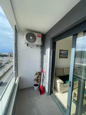 a room with a balcony with a fan and a window at Triumph residence Bar in Bar