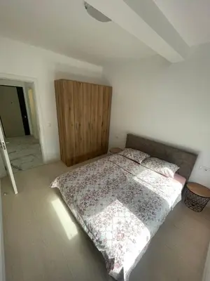 a bedroom with a bed and a wooden cabinet at Triumph residence Bar in Bar