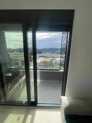 an open glass door with a view of a building at Triumph residence Bar in Bar