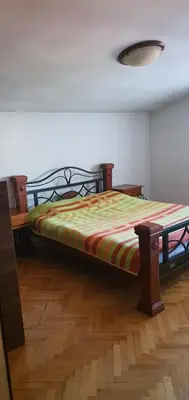 a bed in a room with a wooden floor at Vila Anika in Podgorica