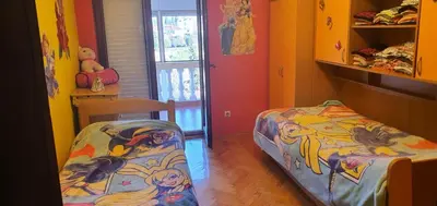 a bedroom with two beds and a door with a window at Vila Anika in Podgorica