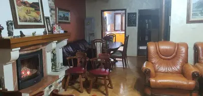 a living room with a fireplace and a table and chairs at Vila Anika in Podgorica