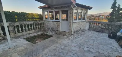 a small house with a fence and a stone patio at Vila Anika in Podgorica