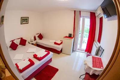 a small room with two beds and a window at Guest House Vucicevic in Budva