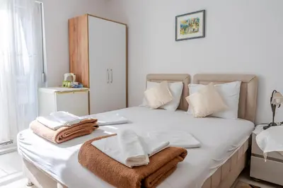 a bedroom with a white bed with towels on it at Guest House Vucicevic in Budva